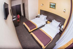 ウリヤノフスクにあるHotel Best-Zuroのベッド2台とテレビが備わるホテルルームです。