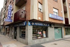 una tienda frente a un edificio con letreros. en Hostal Hispanico II, en Salamanca