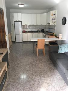 a kitchen and living room with a couch and a table at Apart Juan de Cardona in Arinaga