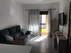 a living room with a couch and a television at Apart Juan de Cardona in Arinaga