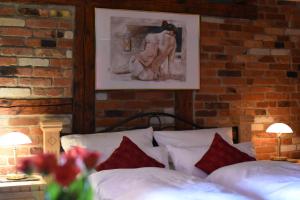 um quarto com uma parede de tijolos e uma cama com almofadas vermelhas em Ferienwohnung Casa da Maria em Langelsheim