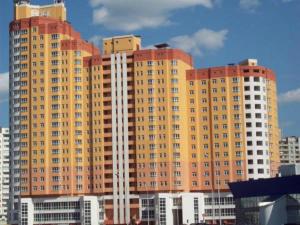 a large yellow building with many windows in a city at Mini Hotel on Poznyaky in Kyiv