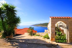 a gate to a house with a view of the ocean at Apartments Ranko in Zavalatica
