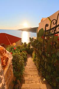 a garden with a fence and a pathway with flowers at Apartments Ranko in Zavalatica