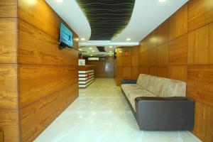 a waiting room with a couch and a flat screen tv at The Pacific Hotel in Vadodara +43 photos