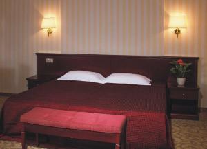 1 dormitorio con 1 cama grande con colcha roja en Park-hotel, en Perm