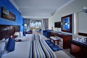a hotel room with a bed and a television at Sea Beach Aqua Park Resort in Sharm El Sheikh