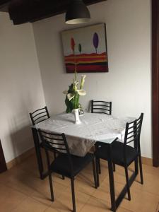 a dining room table with chairs and a vase with flowers on it at Casa da Maria in Prazeres