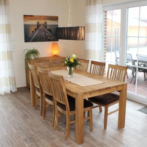 comedor con mesa de madera y sillas en Ferienhaus Seestern, en Garrel