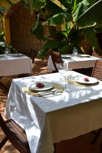a table with white table cloth and plates and glasses at Guest House Orquidea in Sal Rei