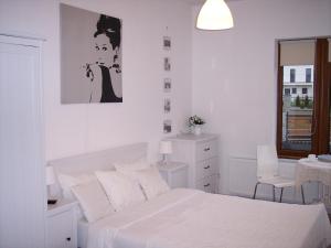 Un dormitorio blanco con una cama y una ventana. en Willa Oliwia, en Ustka