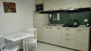 a kitchen with white cabinets and a table and a sink at Casa Millegrü in Pisa