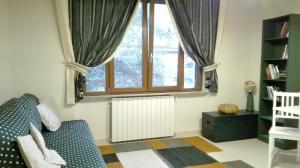 sala de estar con sofá y ventana en Casa Millegrü, en Pisa
