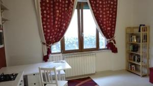 ピサにあるCasa Millegrüの窓、テーブル、椅子が備わる客室です。