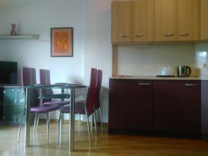 eine Küche mit einem Tisch und lila Stühlen in einem Zimmer in der Unterkunft Apartment Budapeshta in Sofia