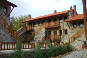a large brick building with wooden decks on it at Enastron in Palaios Agios Athanasios