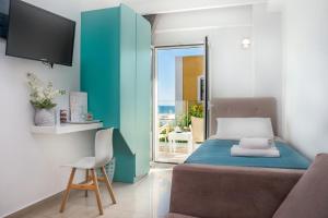 a bedroom with a bed and a tv and a chair at Coral Hotel in Ierapetra