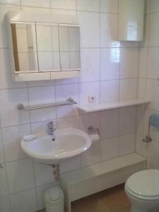 a white bathroom with a sink and a toilet at Ferienhaus Meike im Naturpark Bayr in Zandt