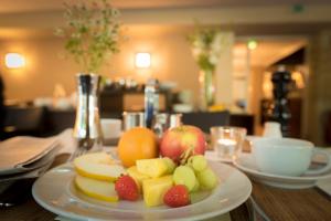 a plate of fruit sitting on a table at Altera Hotel in Oldenburg