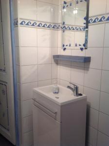 Baño blanco con lavabo y espejo en Gîte CHEZ VÉRO, en Breitenbach-Haut-Rhin