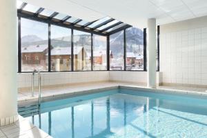 a swimming pool with a view of the mountains at Résidence Odalys Aquisana in La Salle Les Alpes