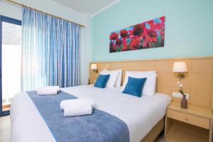 Habitación de hotel con 2 camas y almohadas azules y blancas en Hotel Sunshine en Kamari