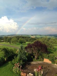 un arco iris en el cielo sobre un campo con árboles en Ferienwohnung Ernle, en Bad Wurzach