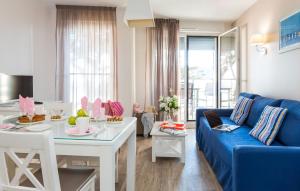 uma sala de estar com um sofá azul e uma mesa em Résidence Prestige Odalys De La Plage em Pornichet