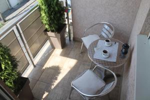 a table and chair on a balcony with a cup of coffee at Apartment Cerska MRB in Belgrade