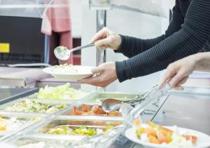 un grupo de personas que sirven comida en un buffet en Albergue Inturjoven Jaen, en Jaén