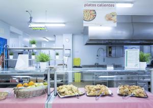 una cocina con varias bandejas de comida en una mesa en Albergue Inturjoven Jaen, en Jaén