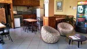 a restaurant with tables and chairs and a kitchen at Aparthotel San Francisco in Santiago