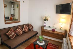 a living room with a couch and a tv at Hostal Cordillera in Punta Arenas