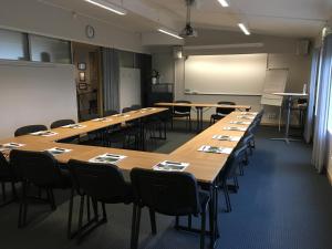 een klaslokaal met lange tafels en stoelen en een whiteboard bij Vandrarhem Svanen in Kalmar