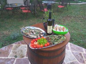 a table with a plate of food and a bottle of wine at Apartmani Villa Radovic in Risan +60 photos