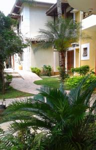 een huis met een palmboom ervoor bij Pousada Vento Norte in Ilhabela