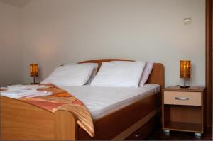 a bed with two night stands with two lamps on it at Apartmani Villa Radovic in Risan