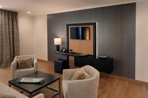 een woonkamer met stoelen, een tafel en een spiegel bij Hofhotel Grothues-Potthoff in Senden