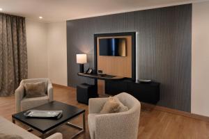 a living room with chairs and a table and a mirror at Hofhotel Grothues-Potthoff in Senden