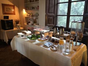 una mesa con un mantel blanco con comida. en Villa Rucellai, en Prato