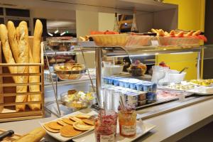 - une boulangerie avec du pain et des viennoiseries sur un comptoir dans l'établissement Colmar Hotel, à Colmar