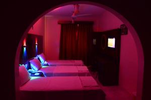 a purple room with a bed and a couch at Tehran Hotel in Dubai