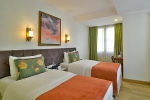 a hotel room with two beds and a couch at Istanbul Life Hotel in Istanbul