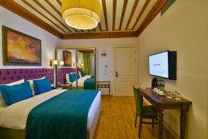 a hotel room with a bed and a desk and a tv at Istanbul Life Hotel in Istanbul