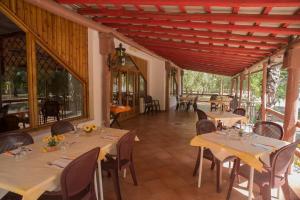 a dining room with tables and chairs and windows at Camping Almoetia in Calatabiano