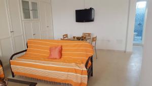 um sofá laranja com uma almofada vermelha num quarto em Appartement à Houmt Souk Jerba em Houmt Souk