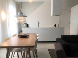a dining room with a wooden table and a kitchen at Urban Residences Maastricht in Maastricht