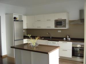 a kitchen with white cabinets and a black counter top at C D Domínguez in Icod de los Vinos