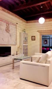 Apartment Gloria في قصرش: غرفة معيشة مع أريكة بيضاء وطاولة