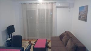 - un salon avec un canapé et une télévision dans l'établissement Apartman Pažin, à Trebinje